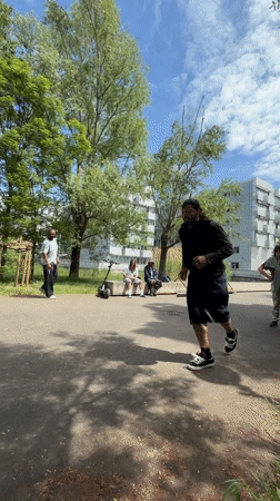 Man performs scooter tricks in sunny Lyon park
