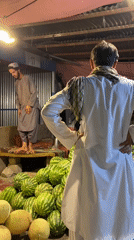 Watermelon vendor and customer at a Kandahar night market