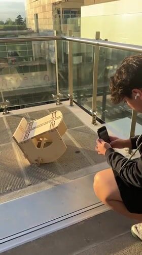 Mexico City residents document wooden craft assembly on balcony