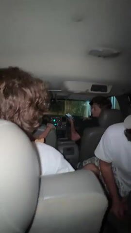 The camera, in the back seat of a car, pans around to show a group of people, mostly women, riding in the vehicle. Some of them are looking at their phones. The audio contains music.