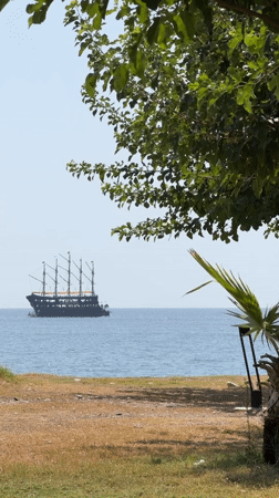 Summer morning on Kemer's pebble beach, ships and seagulls included