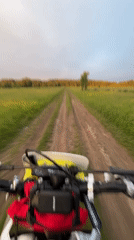 Dirt bike rider travels rural road at sunset