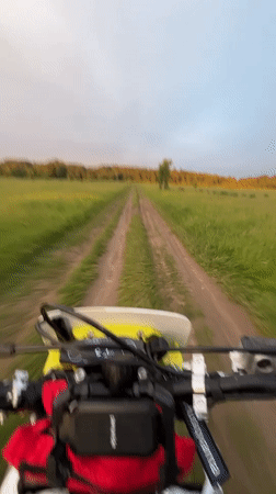 Dirt bike rider travels rural road at sunset