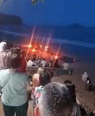 Tourists gather around beach bonfire at Ban Ao Nang