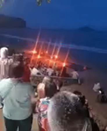 Tourists gather around beach bonfire at Ban Ao Nang
