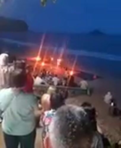 Tourists gather around beach bonfire at Ban Ao Nang