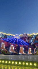 Carnival rides operating at evening amusement park May 14