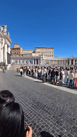 Morning crowds gather at St. Peter's Square under sunny skies