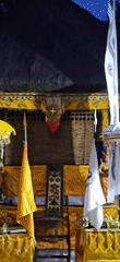 Men prepare traditional decorations at illuminated Balinese temple
