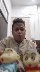 Man plays with cartoon toys indoors in Lhokseumawe