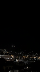 Shimla's illuminated hillside cityscape after dark