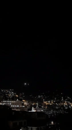 Shimla's illuminated hillside cityscape after dark