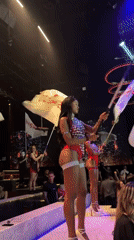 Late-night stage show in Plovdiv club, performers waving branded flags