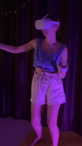 Woman uses VR headset in purple-lit room in Thailand