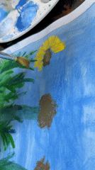 Artist paints sunflowers on blue paper in Guayana City