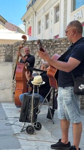 Street musicians perform near Roman landmarks in Pula, Croatia