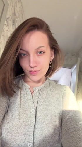 Woman records selfie videos in kitchen, Reshetnikovo Russia