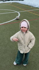 Toddler plays soccer with adults on Russian sports field