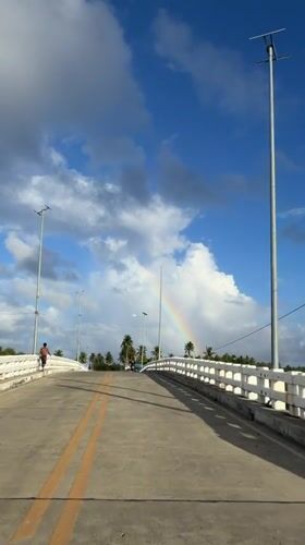 Rainbow appears over General Luna, Philippines bridge scene