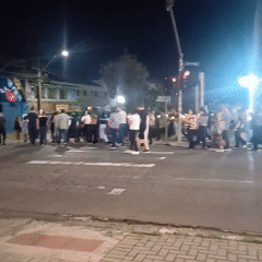 Diverse group crosses street at night in Curitiba