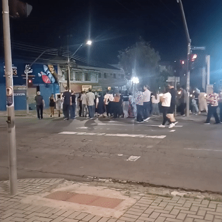 Diverse group crosses street at night in Curitiba