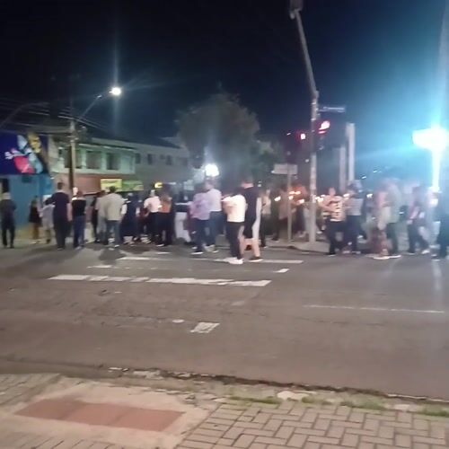 Diverse group crosses street at night in Curitiba