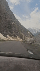 Vehicle travels through snowy mountain pass in Tajikistan