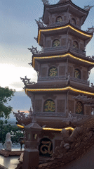 Illuminated pagoda with lion statue captured at sunset Vietnam