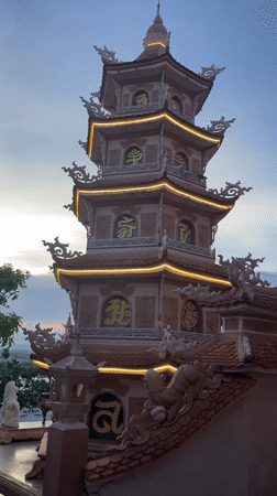 Illuminated pagoda with lion statue captured at sunset Vietnam