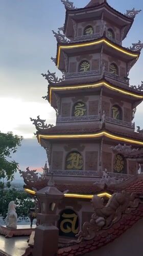 Illuminated pagoda with lion statue captured at sunset Vietnam