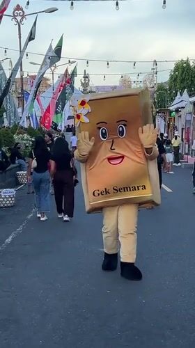 Book mascot walks street waving in Klungkung Indonesia