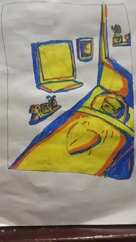 This is a child's drawing of a bedroom scene. A person, likely a child, is sleeping in a bed covered by a yellow blanket with a heart design. A laptop sits on a desk or shelf, and a framed picture is on the wall above it. A toy train with a mouse figure is on a shelf. Another shelf above the bed holds two small figurines. The drawing uses bold outlines in blue and orange, with yellow as the dominant color for the bed and laptop, suggesting a bright and cheerful atmosphere. The overall impression is one of a cozy, personal space, possibly a child's bedroom, depicted with childlike enthusiasm and imagination. There are no discernible time of day, weather, or specific location cues within the drawing itself, though the provided location context is Gampong Blang, Indonesia.
