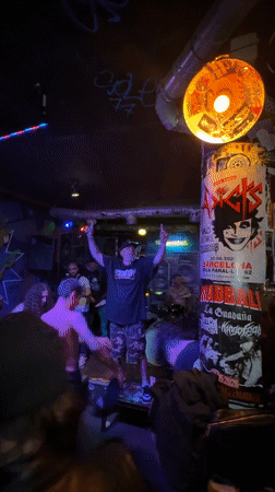 Three people gather in Barcelona bar with musical equipment
