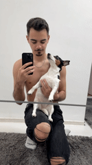 Young man takes mirror selfies with small dog in Sofia