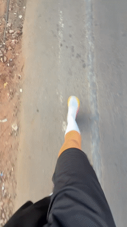 Person walks paved road in Calangute wearing casual attire