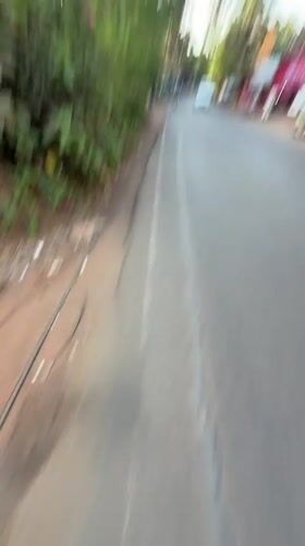 Person walks paved road in Calangute wearing casual attire