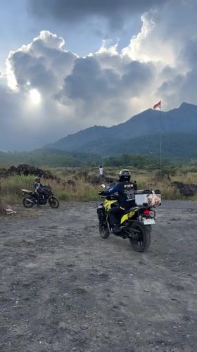 Two motorcyclists pause in volcanic landscape near Kintamani