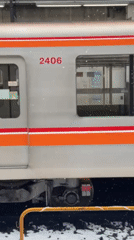 Train arrives at snowy Nakano station, doors opening