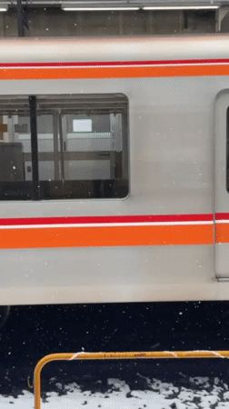 Train arrives at snowy Nakano station, doors opening