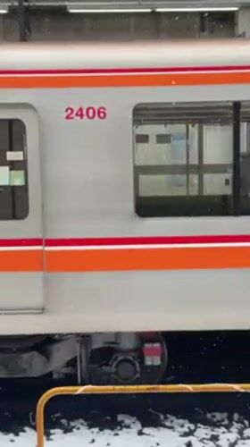 Train arrives at snowy Nakano station, doors opening