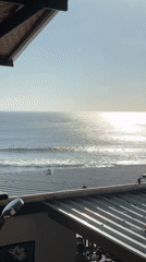 Morning surf session observed from beachfront bar in Kuta