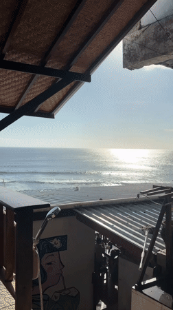 Morning surf session observed from beachfront bar in Kuta