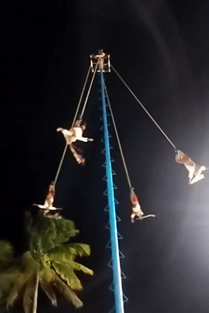 Traditional Voladores ritual performed at night in Playa del Carmen