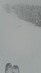 Skier rides lift in snowy conditions at Bansko resort