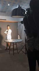 Polished studio pose in white blazer against gray backdrop
