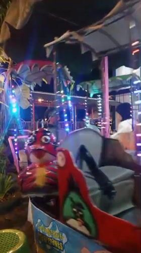 Kids on carnival rides at Taman Kota Sumbersari after dark