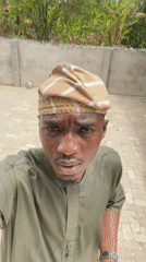 Man takes selfies in traditional dress in Badagry