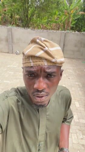 Man takes selfies in traditional dress in Badagry