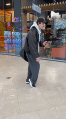 Man in casual attire observed walking through indoor mall
