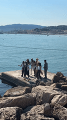 Group dances on sea platform at crowded Cannes beach